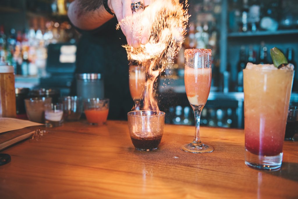 Bartender lighting cocktail on fire